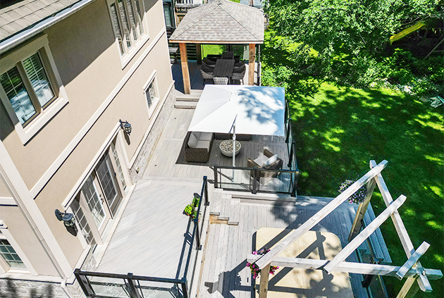 Aerial view of composite deck in backyard, outdoor living space with a pergola, pavilion, and fire pit